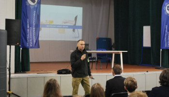 Policjant prelegent, w tle na ekranie prezentacja