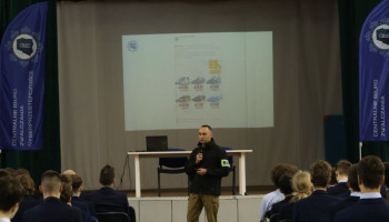 Policjant prelegent, w tle na ekranie prezentacja