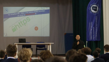 Policjant prelegent, w tle na ekranie prezentacja