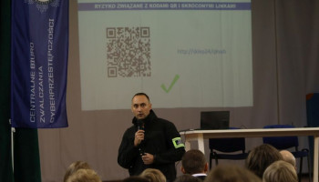 Policjant prelegent, w tle na ekranie prezentacja