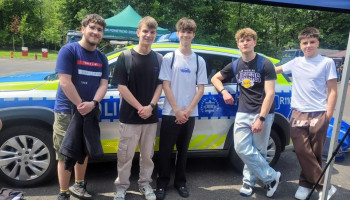 Grupa 5 uczestników szkoły na tle samochodu Policji