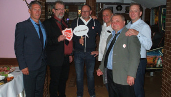 6 absolwentów podczas spotkania, jeden z plakietką „35 lat za nami”, inny z tarczą Śl.TZN