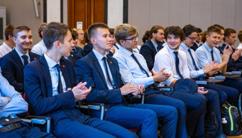 uczniowie siedzą i klaszczą