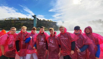 Uczniowie w pelerynach przeciwdeszczowych na statku nad Wodospadem Niagara