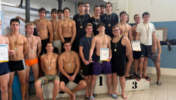 Zawodnicy na podium – w środku nasza sztafeta, 7 chłopców w czarnych koszulkach i jeden z dyplomem w spodenkach