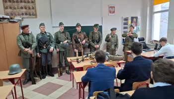 grupa rekonstrukcyjna (7 chłopców w mundurach) prezentuje się klasie