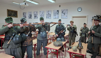 pokaz użycia broni przez 3 chłopców; 4 inni stoją z prawej strony