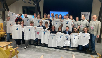 uczestnicy HAKTONU po wylosowaniu zespołów (nr zespołów na białych koszulkach, które trzymają w rękach) oraz opiekunowie i mentorzy