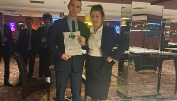 Uczeń prezentujący dyplom w towarzystwie nauczycielki