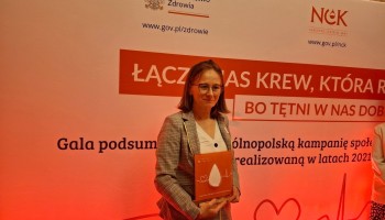 Pani Marta Łyczba podczas gali, trzyma statuetkę