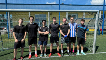 drużyna 3D – 1 miejsce – zwycięska drużyna 7 zawodników w ciemnych strojach piłkarskich na tle bramki