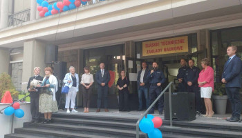 zbliżenie: goście, pani dyrektor, nauczyciel konferansjer, z lewej para w strojach śląskich, przemawia Naczelnik Wydziału Operacyjno-Śledczego