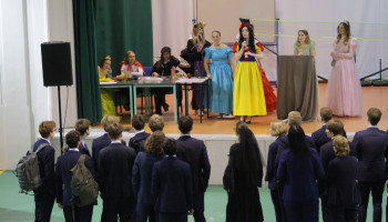 podczas licytacji, prowadząca w stroju Śnieżki, pod sceną stoi grupa uczniów młodszych klas w garniturach